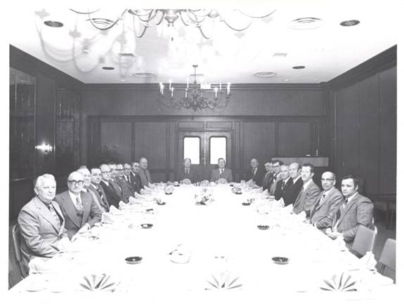 Photo prise en 1975 du conseil d’administration de la coopérative assis à une grande table dans une salle de réunion